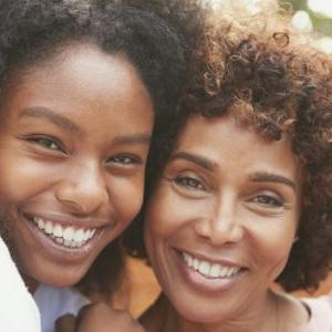 一位妇女和她十几岁的女儿在微笑